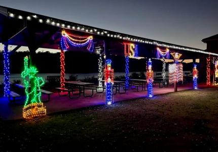 Photo of illuminated light display featuring red white and blue lights of soldiers and swags.  