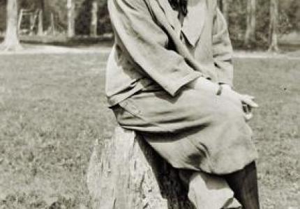 Photographer Clara Weisheit sitting on a stump around 1925
