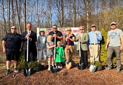 People with shovels in front of the Clegg Trail sign