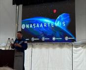 Photo of speaker with artemis image in the background