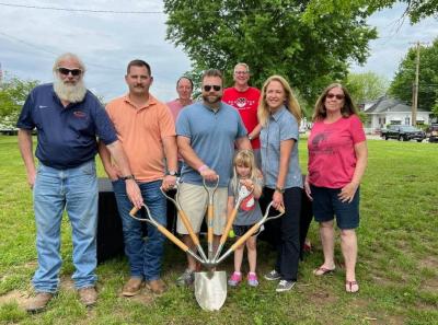 Photo of individuals posing for a ground breaking in a park