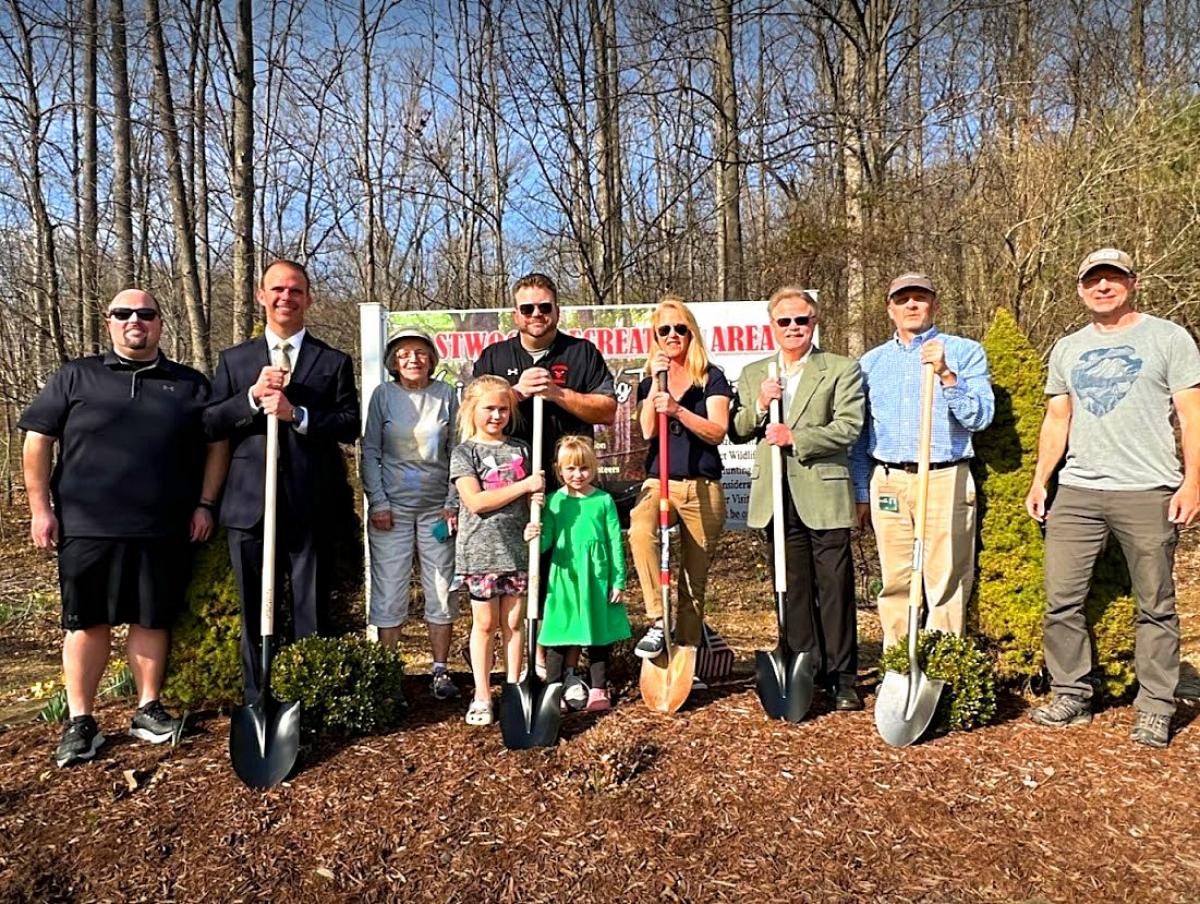 People with shovels in front of the Clegg Trail sign